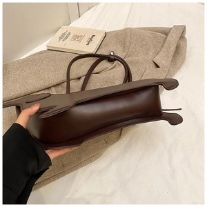 Detail view showing the base and thickness of a dark brown dachshund leather tote bag