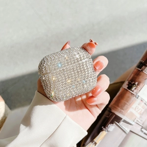 Sparkling silver rhinestones on luxury AirPods case held by hand with shimmering details