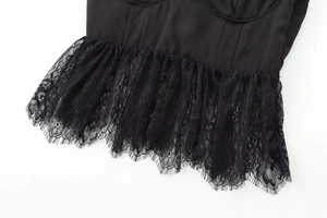 Detailed close-up of intricate black lace trim and stitched fabric hem on a sexy top