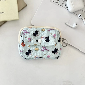 Close-up of light blue quilted mini coin purse with Lucky Kitten's cartoon and metal ring
