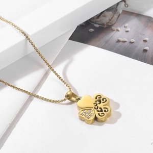 Detail of gold four-leaf clover necklace with sparkling rhinestones and hollow patterns