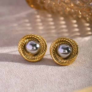 Macro shot of 18k gold braided hoop earrings featuring a polished silver bead detail