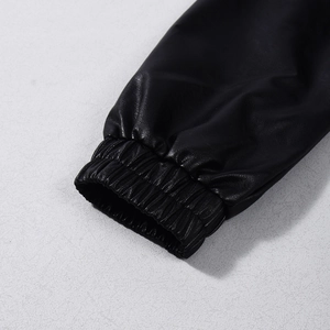 Dettaglio delle maniche della giacca in similpelle nera con polsini elastici a costine