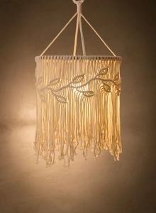 Detailed macro view of macrame lampshade showing handwoven leaf patterns and soft long tassels