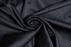 Close-up of black knitted fabric showing soft texture and detailed weave for a mini set
