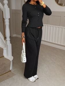 Close-up of black two-piece set featuring button-up shirt and drawstring wide-leg pants