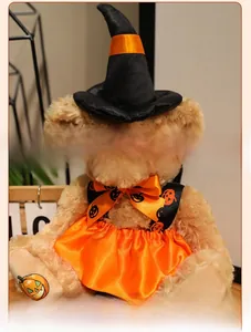 Detail of Halloween witch hat and orange pumpkin dress on a plush teddy bear