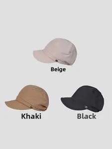 Detail view of cotton newsboy caps in beige, khaki, and black with metal button accents