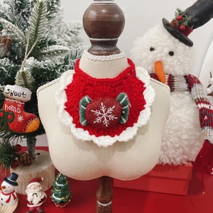 Detail of red crochet pet Christmas bib with snowflake pendant and white lace trim