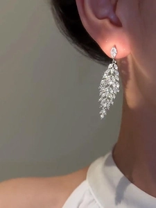 Close-up of model wearing silver leaf tassel earrings with marquise-cut zircons