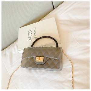 Detail of grey quilted transparent jelly bag with black beaded handle and gold chain strap