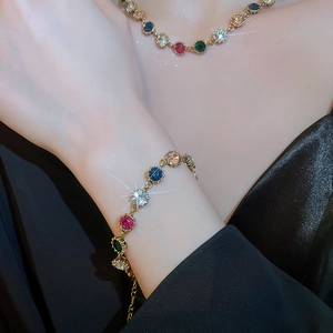 Close-up of luxury bracelet with multicolored gemstones and gold claw settings on wrist