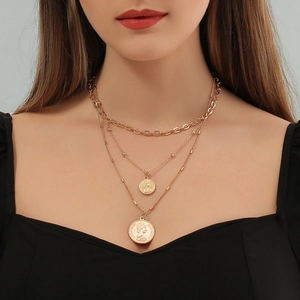 Primer plano del collar multicapa dorado con colgantes de monedas y diseño de capas
