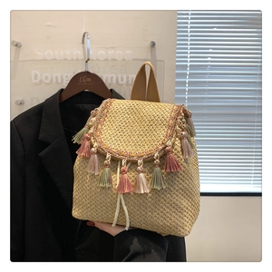 Detail of handmade colorful tassels and straw weave texture on this summer bucket bag