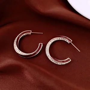 18K gold plated twisted C-shape earrings with deep red enamel and sparkling rhinestones