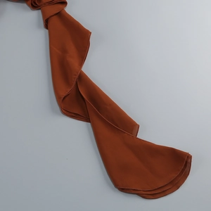 Detail of caramel ruffled chiffon fabric showing soft texture and hemline finish