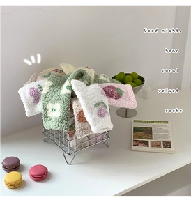 Close-up of colorful coral velvet socks in a wire basket with strawberry patterns