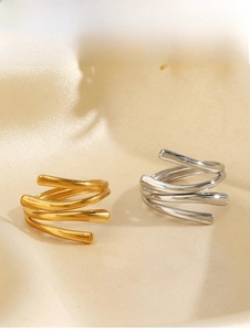 Close-up of geometric spiral triple layer rings in gold and silver finishes