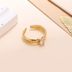 Detail view of gold open ring with twisted texture and oval clear cubic zirconia
