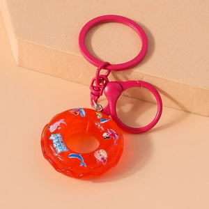 Close-up of creative orange lifebuoy keychain with pink plastic clip and metal ring