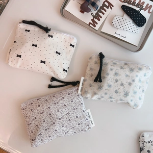 Close-up of floral cotton pouches with zipper tassel detail and simple wish label