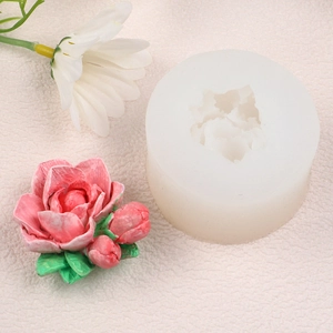 Detailed silicone mold with finished pink 3D rose candle and green leaves on beige background