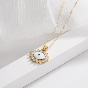 Detailed close-up of a gold evil eye pendant with cubic zirconia on a geometric stand