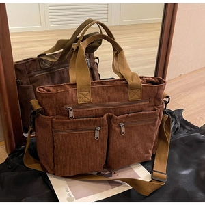 Detail of brown corduroy tote bag with dual handles and adjustable shoulder strap