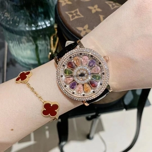 Detail of luxury spinning watch face with crystal stars and floral gem pattern on wrist