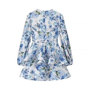 Detailed flat lay of white long sleeve dress featuring blue floral print and layered skirt