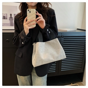 Gros plan d'un sac à main minimaliste en velours côtelé beige avec anses noires