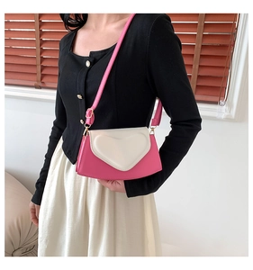 Détail du sac bandoulière avec design de cœur 3D et rabat contrasté blanc texturé