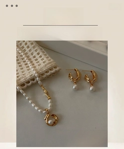 Detailed view of baroque pearl necklace and matching lava-style gold earrings jewelry set