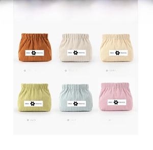 Detail view of corduroy cosmetic bags in six colors with Free Travel floral patches