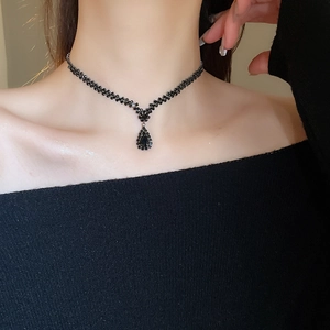 Macro detail of a black crystal pear-shaped Y-necklace on model for elegant look