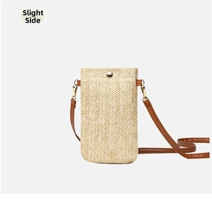 Side view of woven straw crossbody phone bag with brown leather strap and gold button
