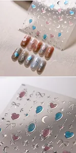 Close-up of M-528 silver embossed nail stickers with pink glitter heart and butterfly