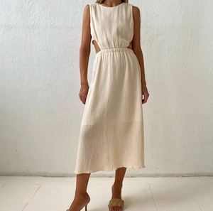 Detail of waist cut-out and textured crinkle fabric on a cream sleeveless midi dress