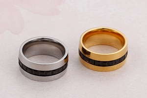 Macro view of wide metal rings with black cubic zirconia inlay in silver and gold colors