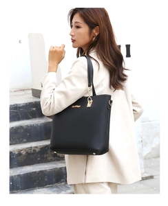 Detailed close-up of black leather tote bag with gold zipper and metallic hardware accents