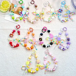 Flat lay of colorful candy-colored beaded phone charms with cute cartoon character beads