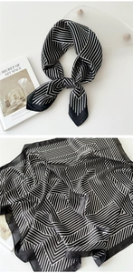 Detailed view of black and white striped satin scarf with knotted styling and geometric texture