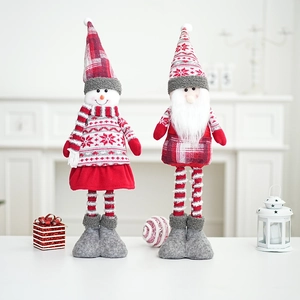 Close-up of Santa and Snowman plush dolls with knit hats and long striped legs for Christmas