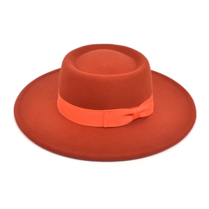 Detail of terracotta wool felt boater hat with matching grosgrain ribbon and bow