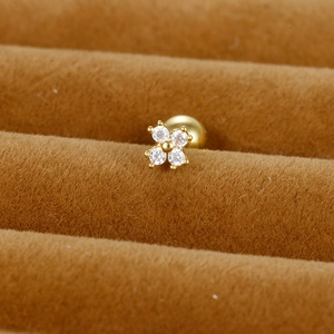 Gros plan détaillé d'un clou d'oreille fleur dorée avec zircons cubiques étincelants