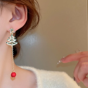 Detail of Christmas tree earrings with green crystals and red pearl tassels on model