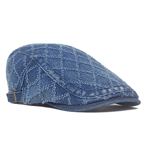 Blue denim flat cap with quilted texture and metal adjustment buckle on white background