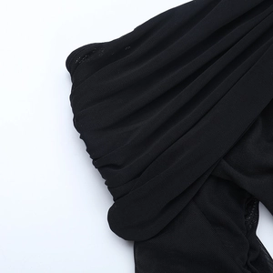Detailed macro shot of sheer black mesh fabric with layered ruffles and fine texture