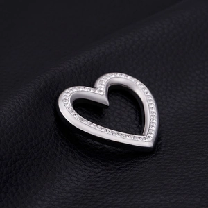 Silver heart pendant with crystal stones on black leather background, elegant jewelry design