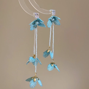 Close-up of light blue lace flower earrings with elegant pearly beaded fringe tassels